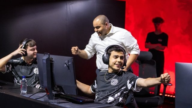 Photo from ALGS Split 2 Playoffs showing TSM Reps fistbumping coach Raven on the left and ImperialHal raching to fist bump Verhulst on the right