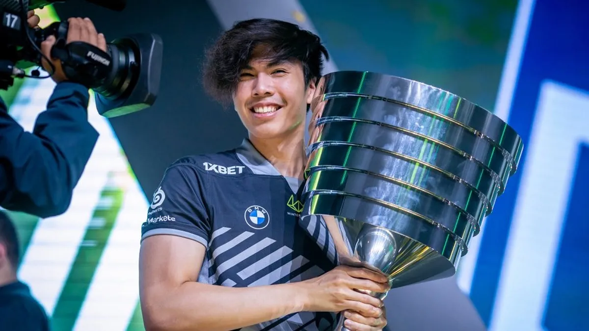 Taiga holding a major Dota 2 trophy.