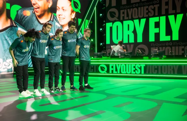 FlyQuest's 2024 LCS roster, featuring Bwipo, Inspired, Jensen, Massu, and Busio, bow after their victory.