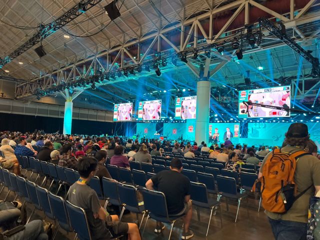 pokemon naic 2024 day one, showing people sitting in seats staring at four screens in front of them