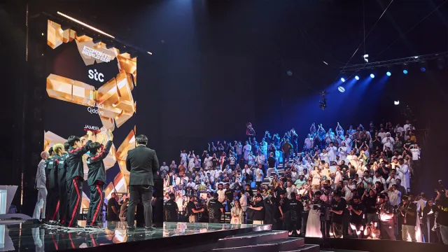 T1's LoL team celebrates their EWC win in front of the Saudi crowd.